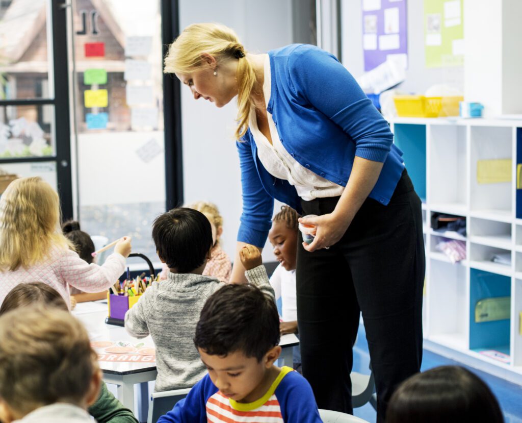 Group of diverse students coloring workbook in class